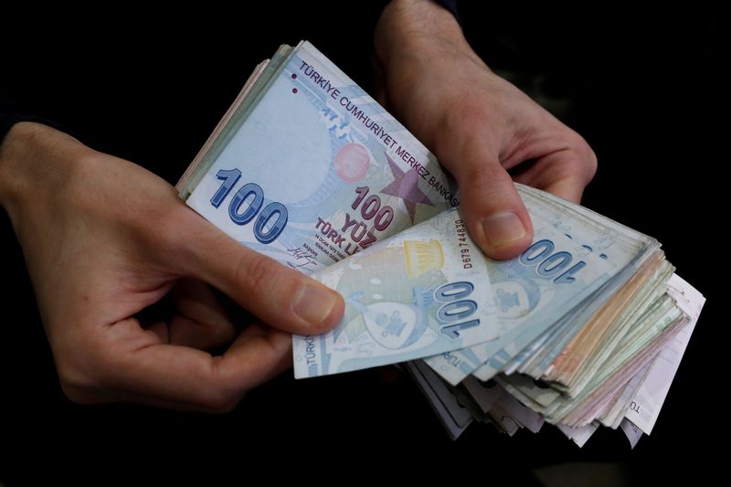 &copy; Reuters. FILE PHOTO: A merchant counts Turkish lira banknotes at the Grand Bazaar in Istanbul