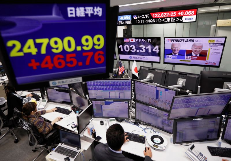 &copy; Reuters. Un operador de mercados mira los monitores con el índice Nikkei y las noticias sobre las elecciones en EEUU en una correduría de Tokio, Japón.