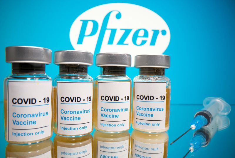&copy; Reuters. Fiale con la scritta adesiva &quot;COVID-19 / Vaccino contro il Coronavirus / Solo iniezione&quot; e una siringa davanti a un logo Pfizer
