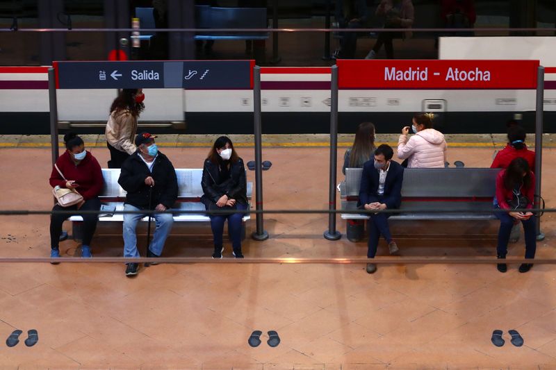 &copy; Reuters. Commuters wearing protective face masks wait on a platform at Atocha train station in Madrid