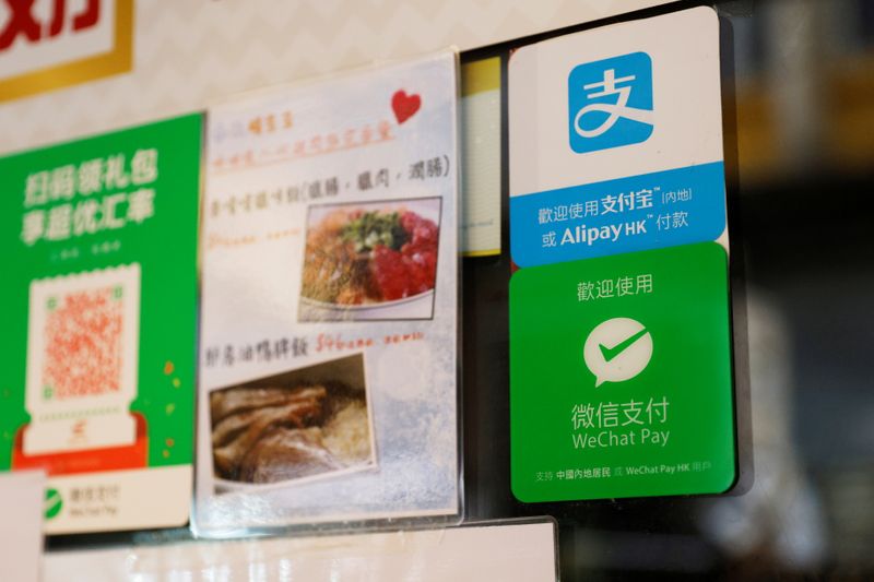 &copy; Reuters. Logos for digital payment services Alipay by Ant Group, an affiliate of Alibaba Group Holding and WeChat Pay by Tencent Holdings are displayed outside a restaurant, in Hong Kong