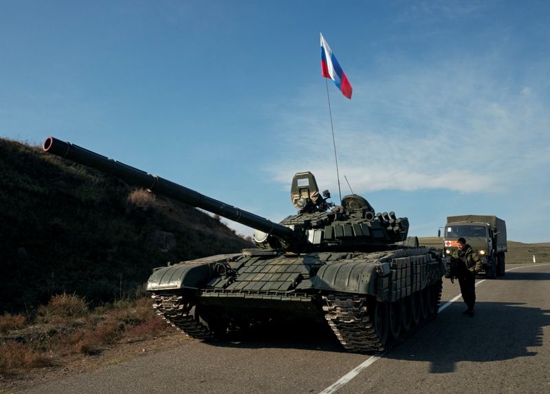 © Reuters. A service member of the Russian peacekeeping troops stands next to a tank in Nagorno-Karabakh