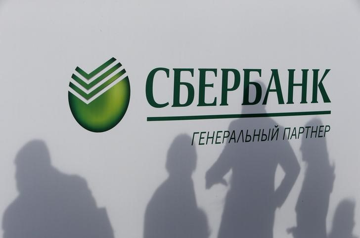 &copy; Reuters. Participants cast their shadows on a board with the logo of Sberbank at the St. Petersburg International Economic Forum