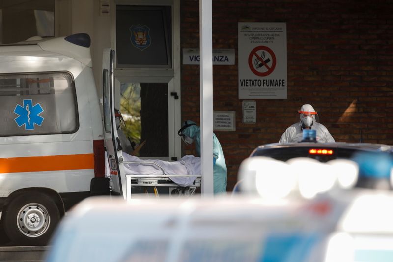 &copy; Reuters. Personale medico munito di dispositivi di protezione trasferisce un paziente dall&apos;ambulanza all&apos;interno dell&apos;ospedale Cotugno di Napoli