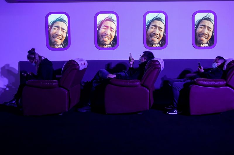 © Reuters. People look at their phones during Alibaba Group's 11.11 Singles' Day global shopping festival at a media center in Hangzhou