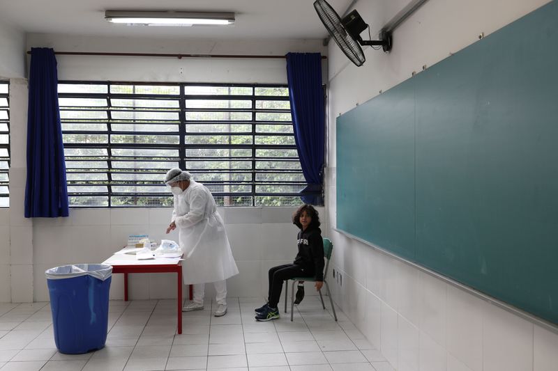 &copy; Reuters. Agente de saúde prepara teste de Covid-19 para aplicar em estudante nos arredores de São Paulo