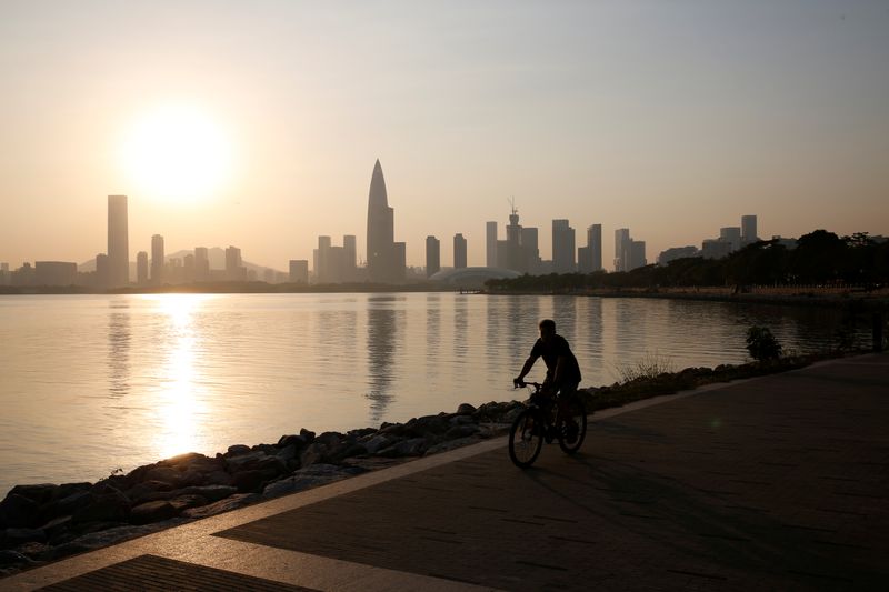 &copy; Reuters. A person rides a bicycle during sunset in front of Shenzhen&apos;s highrise buildings in Shenzhen.