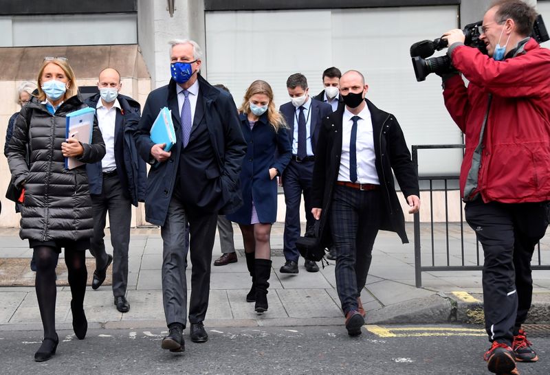 © Reuters. A member of the media points his camera at European Union's chief Brexit negotiator Michel Barnier wearing a face mask as he walks to Brexit trade negotiations in London