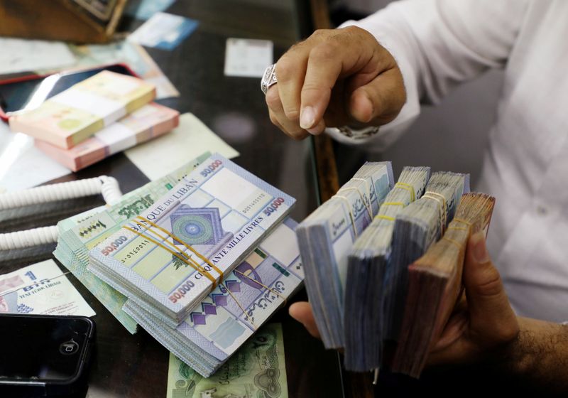 &copy; Reuters. FILE PHOTO: A man counts Lebanese pounds at a currency exchange shop in Beirut