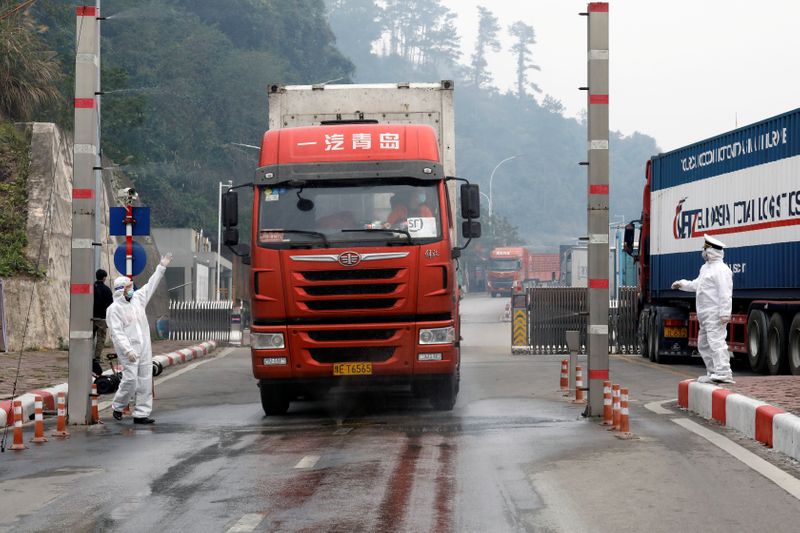 © Reuters. FILE PHOTO: Vietnamese health workers wearing protective suits disinfect a container truck from China at Huu Nghi border gate connecting with China, in Lang Son province