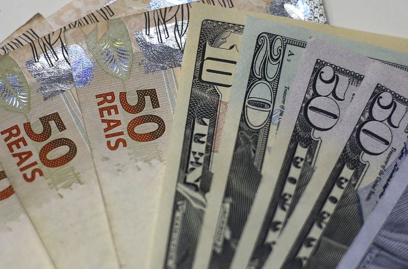 © Reuters. FILE PHOTO: Brazilian Real and U.S. dollar notes are pictured at a currency exchange office in Rio de Janeiro