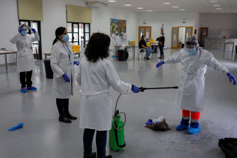 &copy; Reuters. Agente de saúde desinfecta colega após coletarem amostras de moradores para testagem em massa de Covid-19 em Ronda, na Espanha