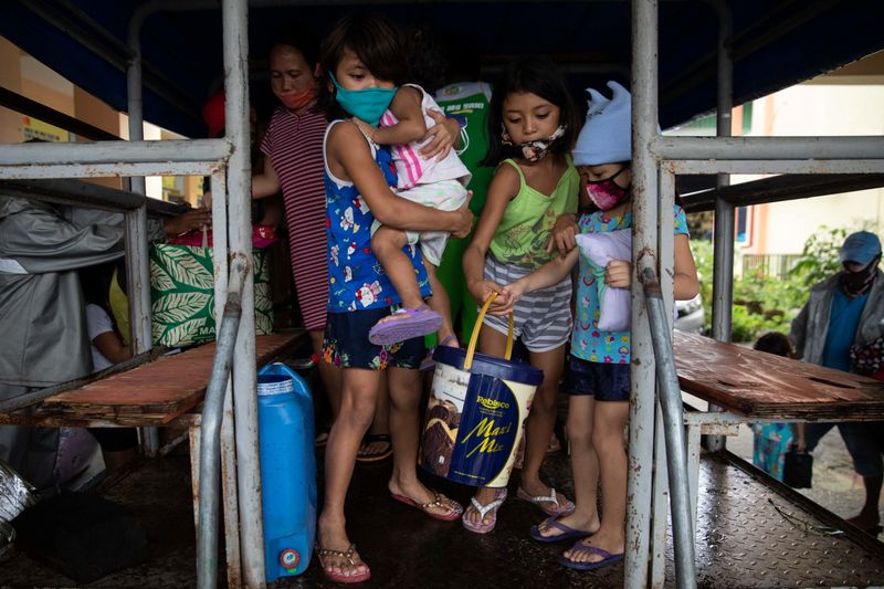 &copy; Reuters. Residents in a coastal community in Metro Manila evacuate ahead of Typhoon Vamco