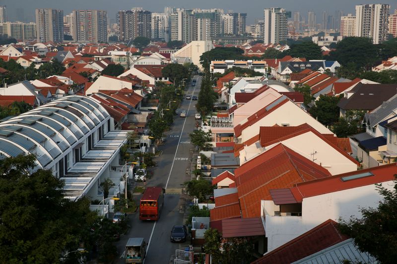 © Reuters. FILE PHOTO: Vehicles pass private landed residential properties at a neighbourhood in Singapore