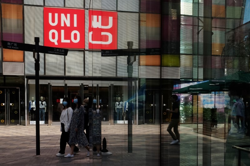 &copy; Reuters. Women walk past a store of the Fast Retailing&apos;s fashion chain Uniqlo, in Beijing