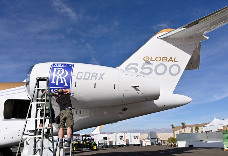 &copy; Reuters. Workers apply a Rolls Royce decal to the engine of a Bombardier Global 6500 business jet at the Bombardier booth at the National Business Aviation Association (NBAA) exhibition in Las Vegas