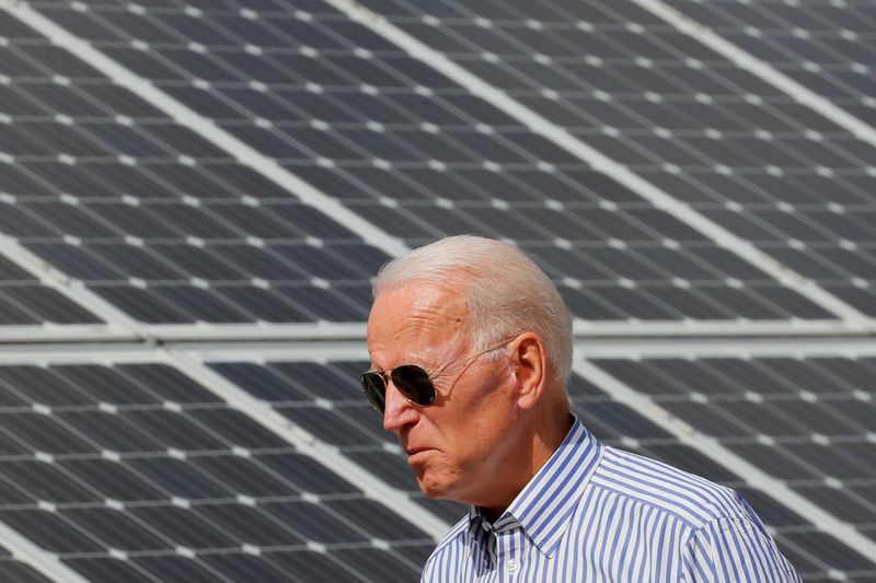 © Reuters. FILE PHOTO: Democratic 2020 U.S. presidential candidate Biden walks past solar panels in Plymouth