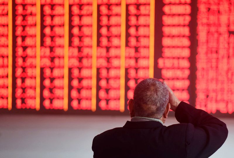 &copy; Reuters. Man sits in front of an electronic board showing stock information at a brokerage house in Hangzhou