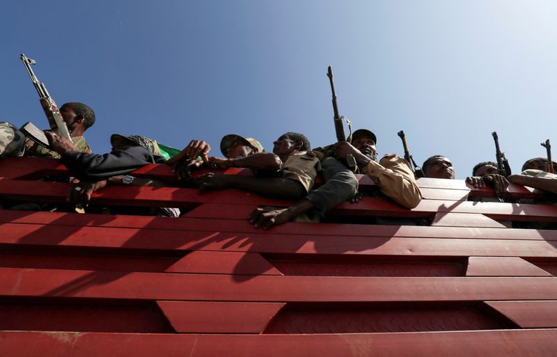 © Reuters. FILE PHOTO: Members of Amhara region militias ride on their truck as they head to the mission to face the Tigray People's Liberation Front in Sanja