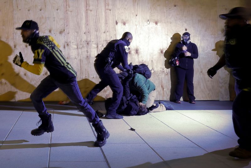 © Reuters. A police officer tries to stop a fight between a member of far-right militia Proud Boys and an anti-facist protester following a protest against election results, in Washington