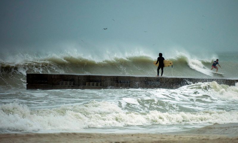 &copy; Reuters. FILE PHOTO: A surfer times the waves before jumping off the jetty into the surf before the arrival of Tropical Storm Eta in Florida