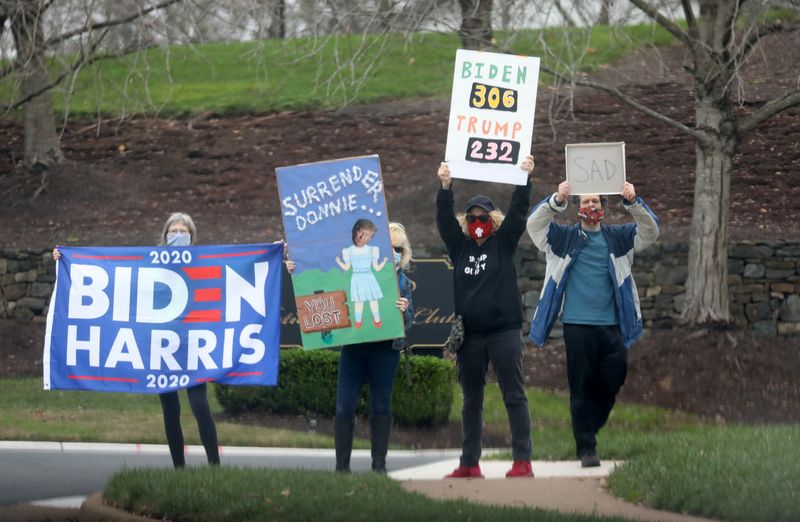 © Reuters. Protesters stand outside the entrance to Trump National Golf Club after U.S. President Donald Trump's motorcade passed by in Sterling, Virgina