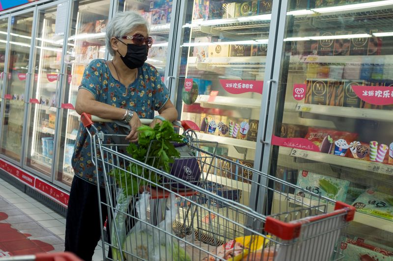 © Reuters. FILE PHOTO: A woman looks at frozen food products in a supermarket in Beijing