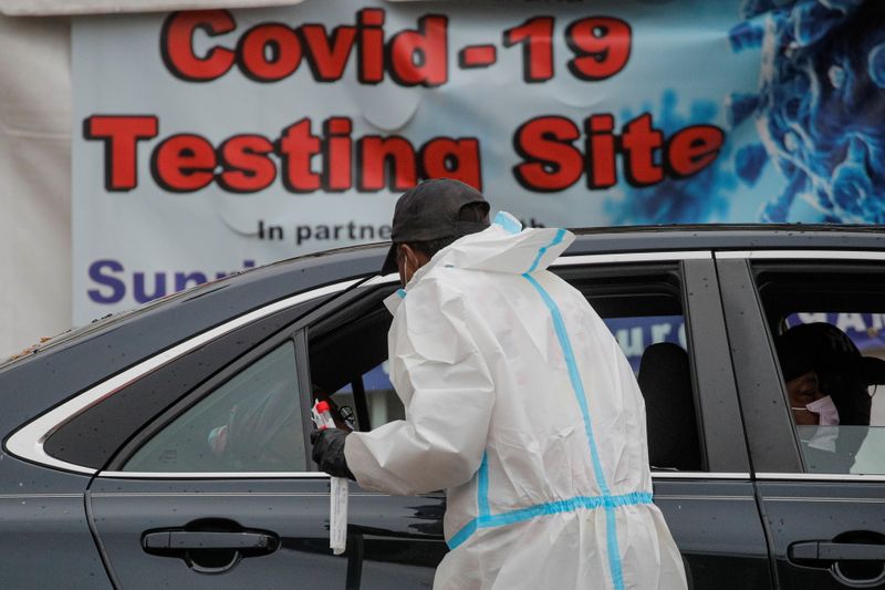 &copy; Reuters. A healthcare worker takes a swab from a person sitting in a car at a drive-thru COVID-19 test center, during a surge in the coronavirus disease (COVID-19) infections in Newark, New Jersey