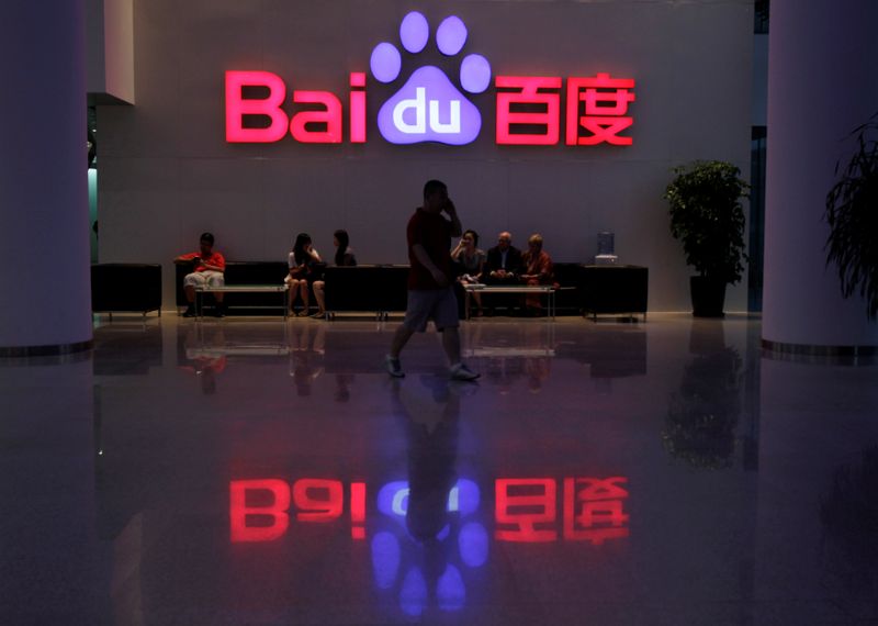 &copy; Reuters. A employee uses his mobile phone as he walks past the company logo of Baidu at its headquarters in Beijing