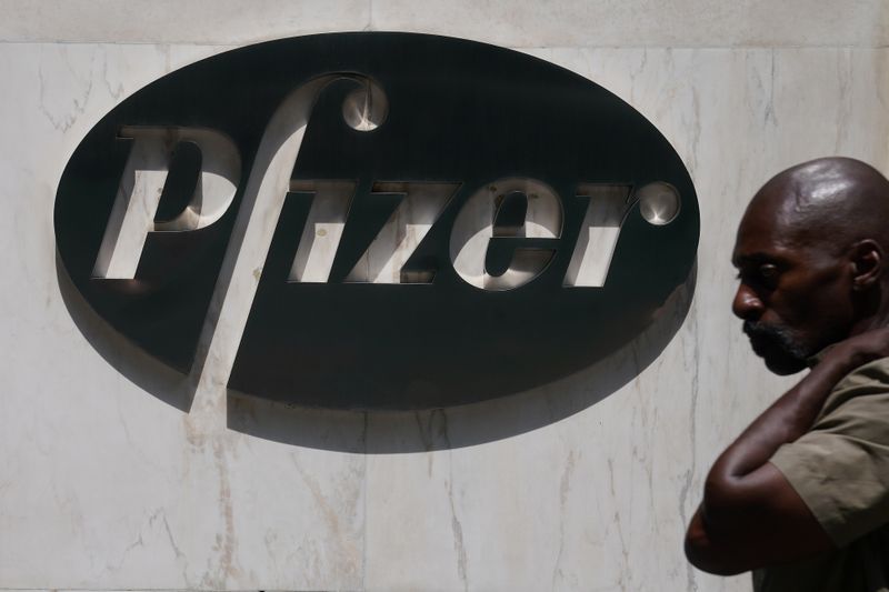 &copy; Reuters. A man walks past a sign outside Pfizer Headquarters in the Manhattan borough of New York City