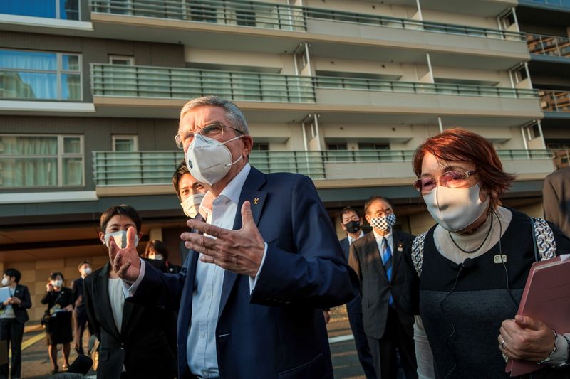 © Reuters. Thomas Bach, International Olympic Committee (IOC) President wearing a protective mask talks to journalists during a visit to Olympic and Paralympic village in Tokyo