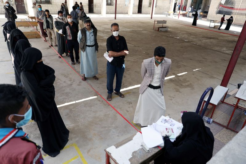 &copy; Reuters. Fila de pessoas para entrega de voucher de alimentação em Sanaa, no Iêmen