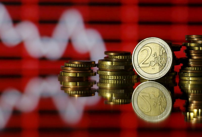 © Reuters. Euro coins are seen in front of a displayed stock graph in this photo illustration