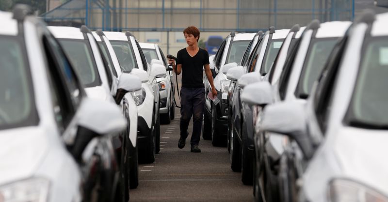 &copy; Reuters. FILE PHOTO: A worker checks cars made by GM Korea in a yard of GM Korea&apos;s Bupyeong plant in Incheon