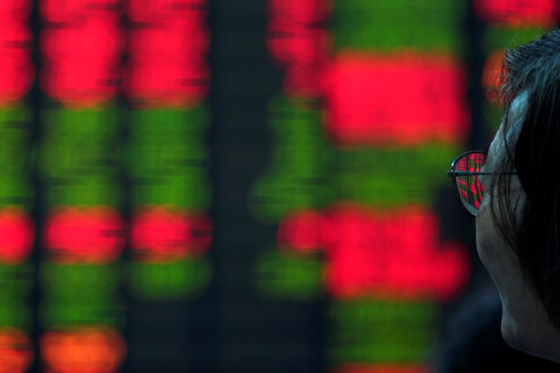&copy; Reuters. Un investitore guarda uno schermo con le informazioni di borsa presso una società di intermediazione a Shanghai