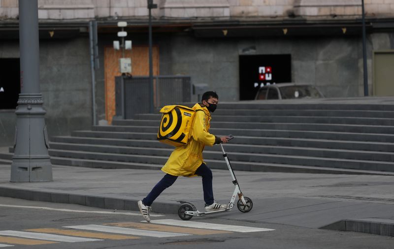 &copy; Reuters. A Yandex.Eats food delivery courier rides a scooter in Moscow
