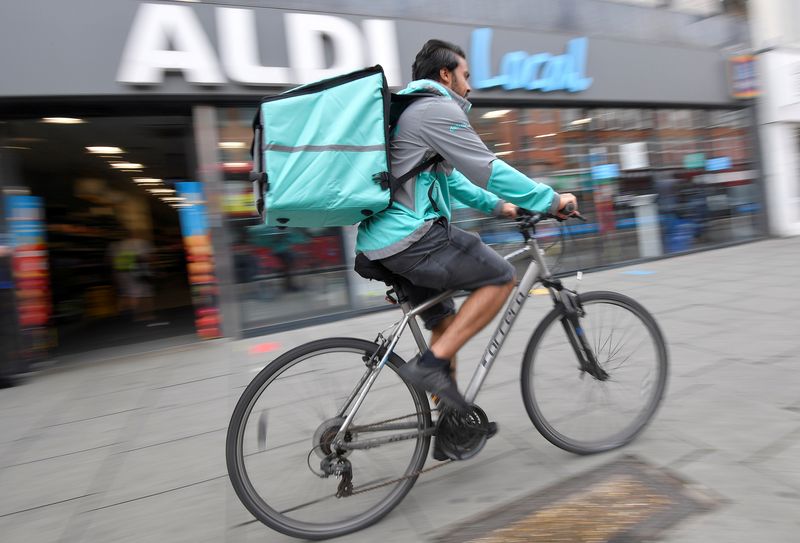 &copy; Reuters. FILE PHOTO: Abdelaziz Abdou, a Deliveroo delivery rider, poses with a bag of Aldi groceries, London