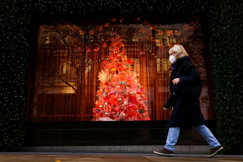 © Reuters. A pedestrian walks past a Christmas tree in a window display at Selfridges department store on Oxford Street amid the coronavirus disease (COVID-19) outbreak in London