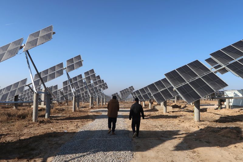 &copy; Reuters. Funcionários caminham em estação de energia solar em Tongchuan, na província chinesa de Shaanxi