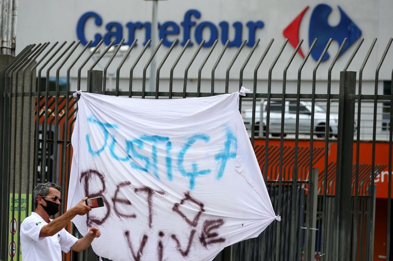 &copy; Reuters. A man takes a picture next to a banner that&apos;s reads: &quot;Justice. Beto lives&quot;, after Joao Alberto Silveira Freitas was beaten to death by security guards at a Carrefour supermarket in Poro Alegre