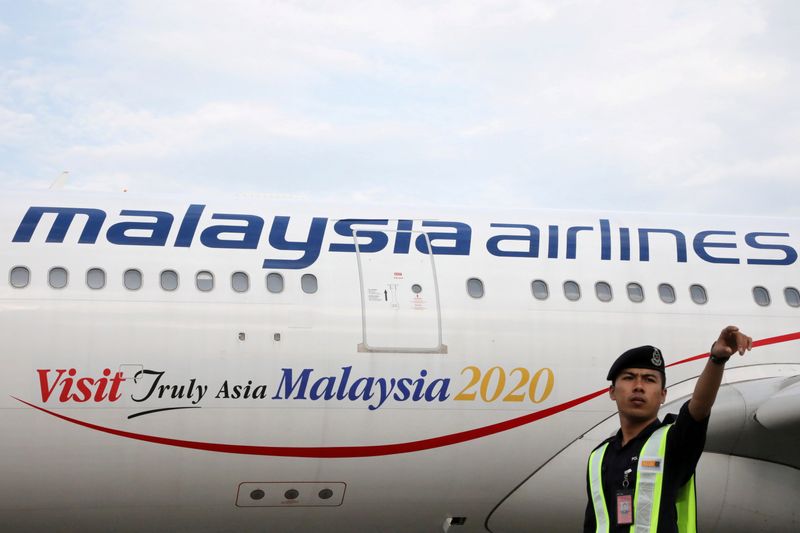 &copy; Reuters. FILE PHOTO: An airport employee beside a Malaysia Airlines plane at Kuala Lumpur International Airport