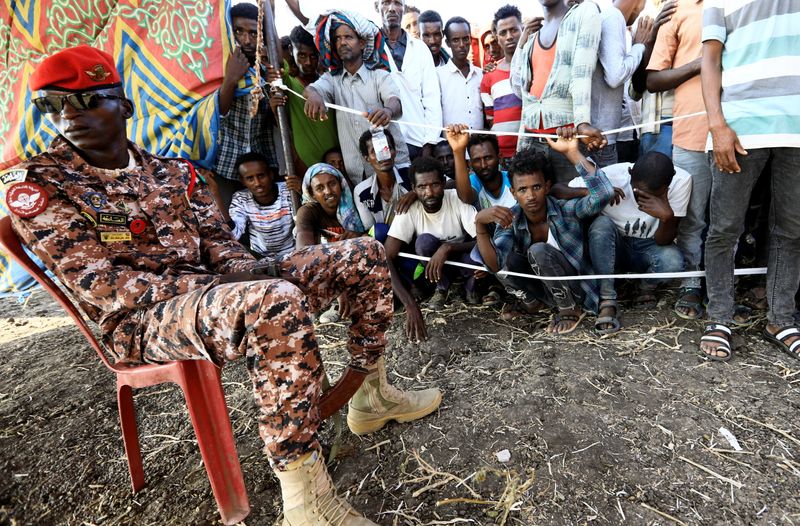 &copy; Reuters. Sudanese military officer keeps guard as Ethiopians who fled war in Tigray region, gather to receive relief supplies from the World Food Programme at the Fashaga camp on the Sudan-Ethiopia border in Al-Qadarif state