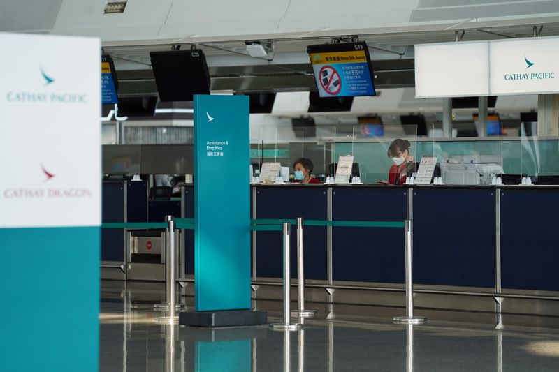 &copy; Reuters. Cathay Pacific employees are seen behind counters with glass dividers at Hong Kong International Airport