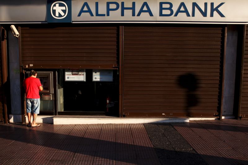 &copy; Reuters. A man withdraws money at an Alpha Bank branch ATM in central Athens