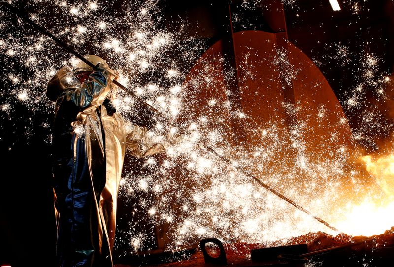 © Reuters. FILE PHOTO: A steel worker of Germany's industrial conglomerate ThyssenKrupp AG stands a mid of emitting sparks of raw iron from a blast furnace at Germany's largest steel factory in Duisburg