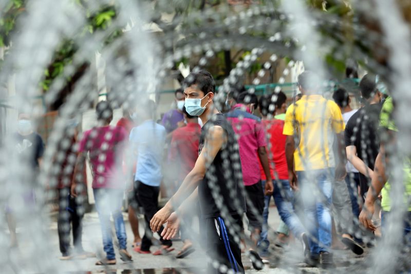 &copy; Reuters. FILE PHOTO: Top Glove workers wait for food distribution outside a hostel under enhanced lockdown in Klang