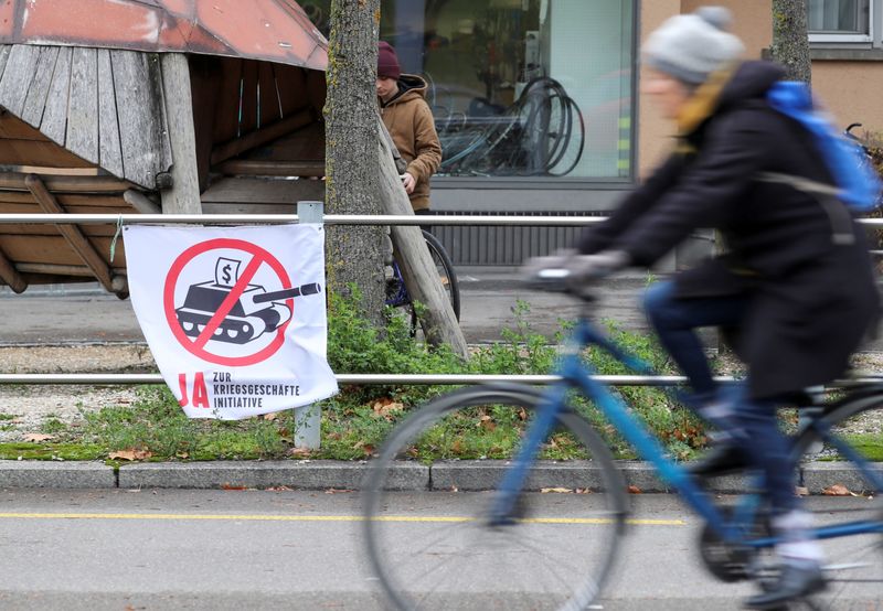 &copy; Reuters. A banner reading &quot;Yes to war business initiative&quot; is placed  on a railing in Zurich