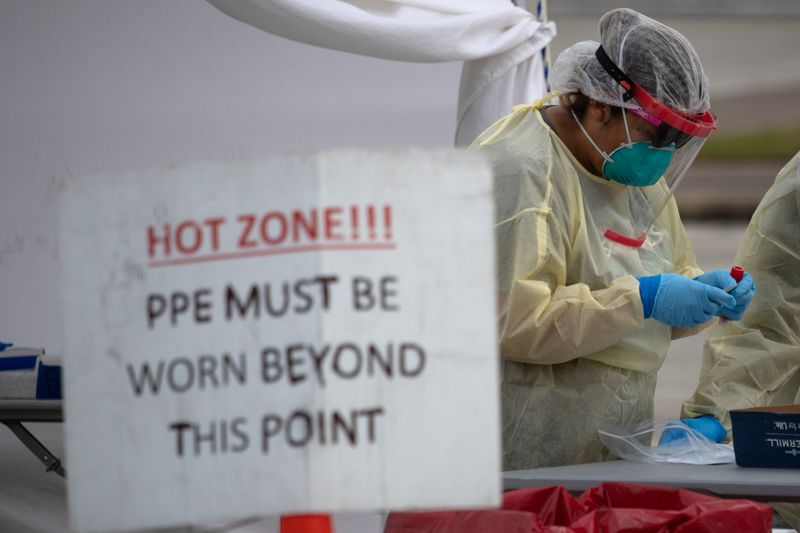 &copy; Reuters. FILE PHOTO: A healthcare worker prepares specimen collection tubes at a coronavirus disease (COVID-19) drive-thru testing location in Houston