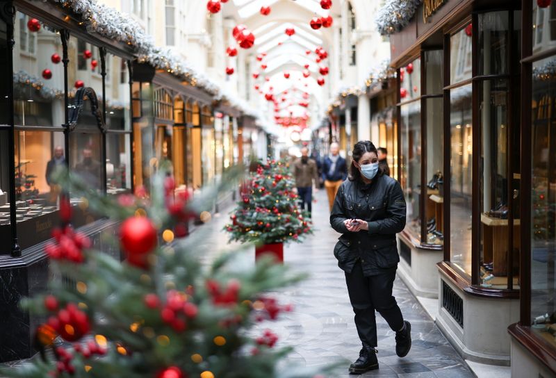 &copy; Reuters. Woman walks through the Burlington Arcade adorned with Christmas decorations, in London