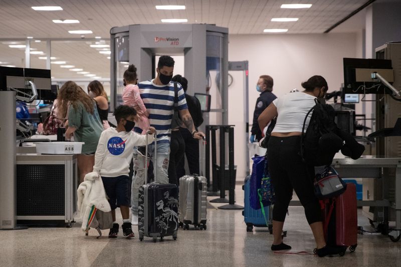 &copy; Reuters. FOTO DE ARCHIVO: Una familia usa mascarillas al pasar la seguridad en la Terminal A del Aeropuerto Intercontinental George Bush en medio del brote de la enfermedad coronavirus (COVID-19) en Houston, Texas, Estados Unidos.